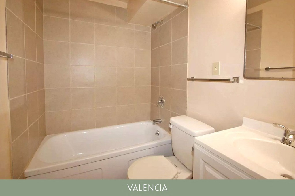 a bathroom with a tub and a sink and a toilet