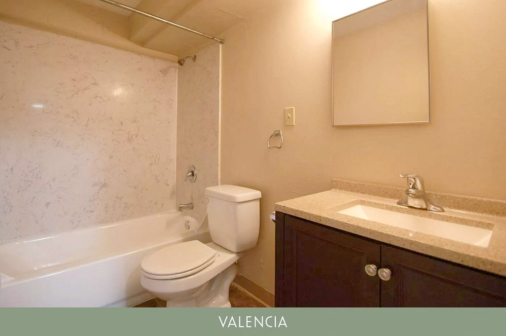 a bathroom with a toilet and a sink and a bath tub