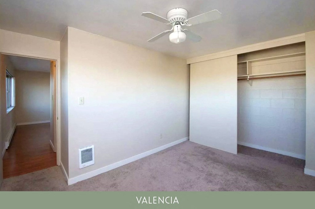 an empty room with a ceiling fan and a closet