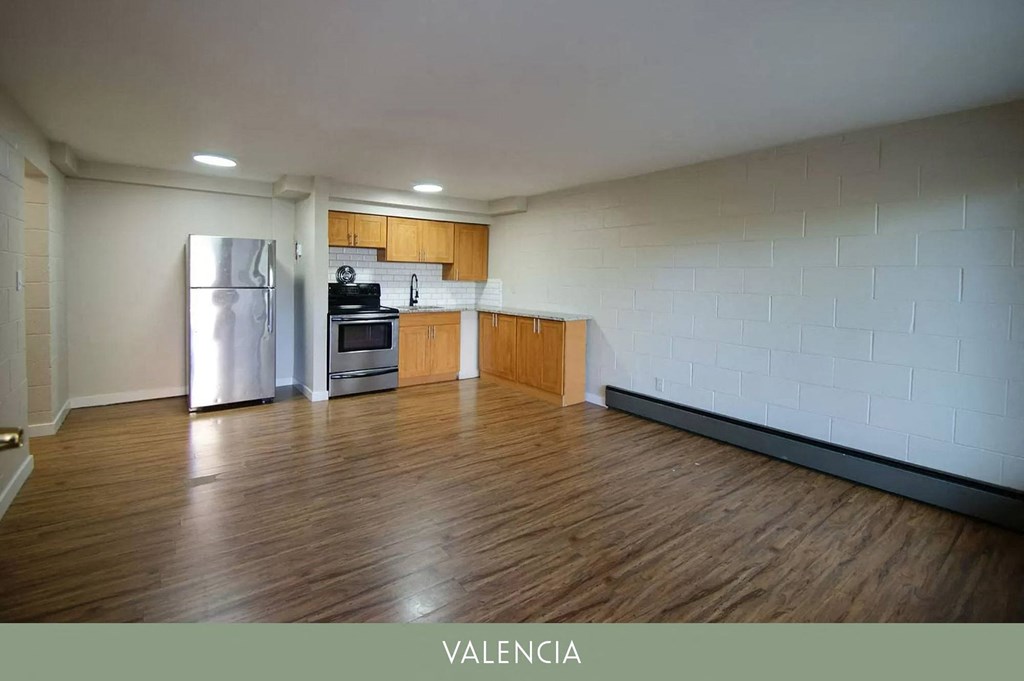 an empty kitchen with a refrigerator and a stove