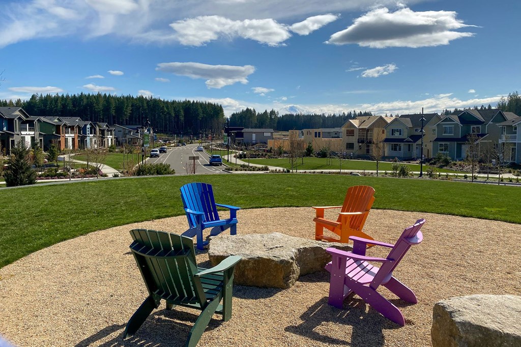 colorful chairs sitting in a circle in front of houses