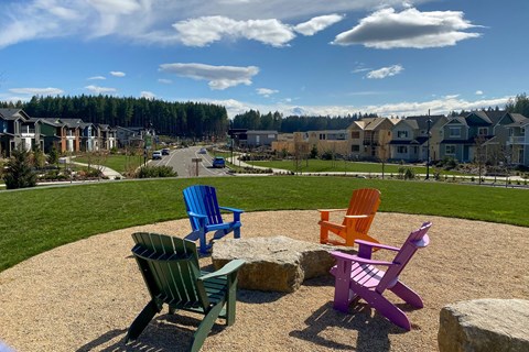 colorful chairs sitting in a circle in front of houses