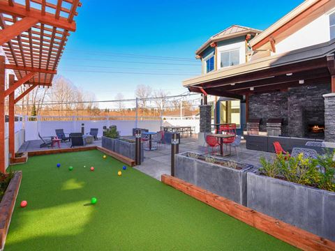 a backyard with a bocce court and a pool with balls on it
