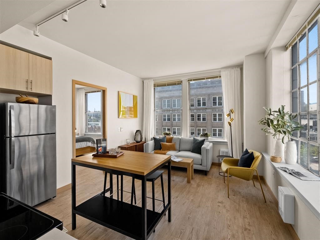 a living room with a large window and a wooden floor