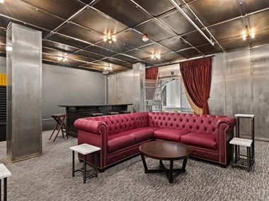 a living room with a red couch and tables