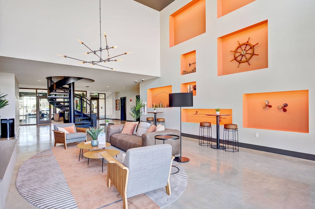 a living room with couches and chairs and a spiral staircase