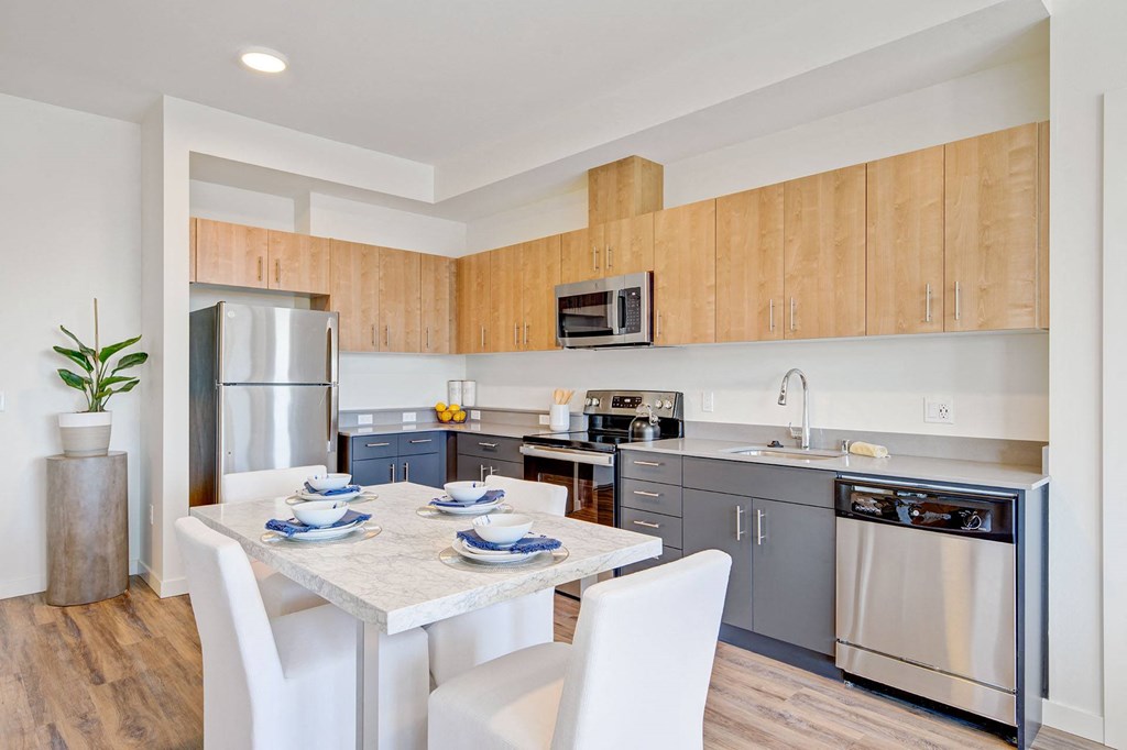 a kitchen with stainless steel appliances and a marble table