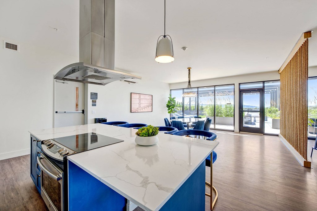 a kitchen and living room with blue chairs and a white counter top