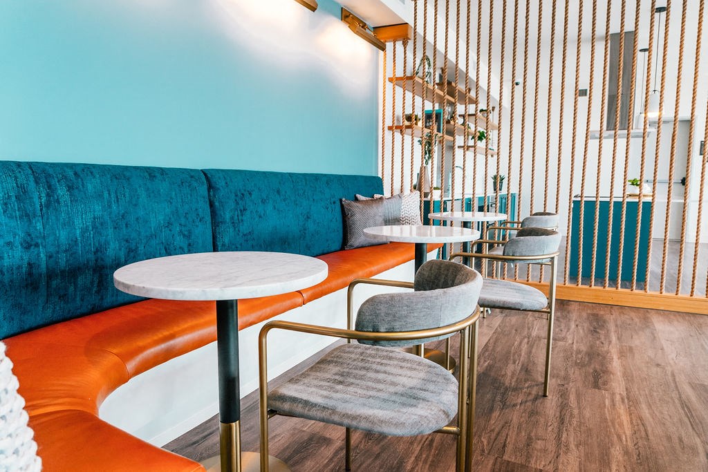 a seating area with tables and chairs and a blue couch