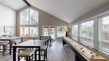 A room with a long table and chairs with a window on the side.