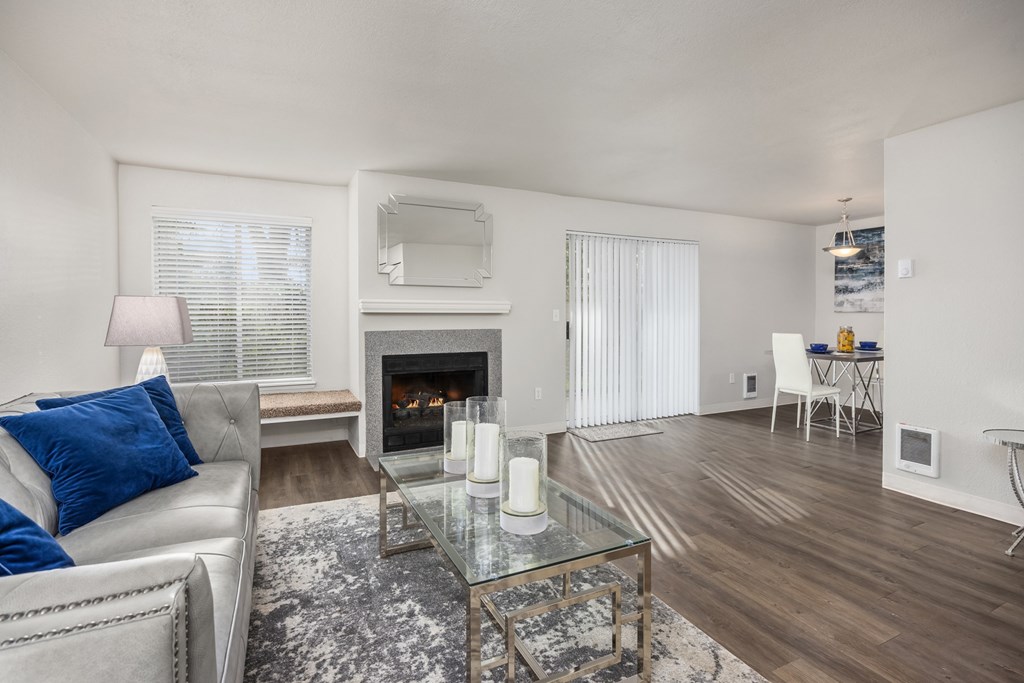 A modern living room with a fireplace and a glass coffee table.
