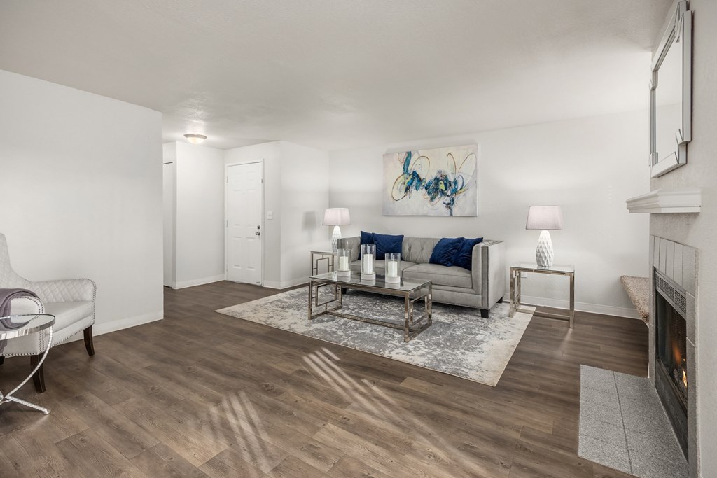 A living room with a white couch, a coffee table, and a fireplace.