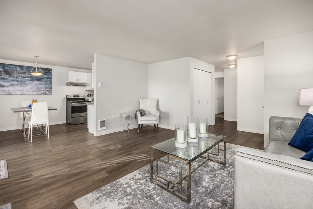 A modern living room with a grey couch and a glass coffee table.