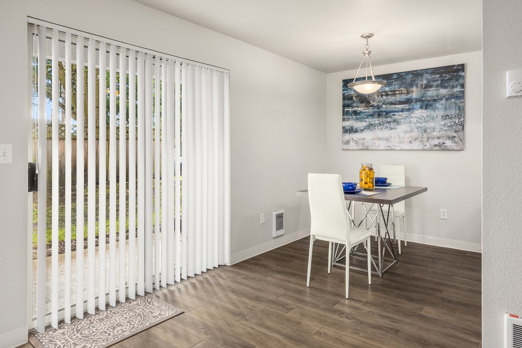A dining room with a white table and chairs.