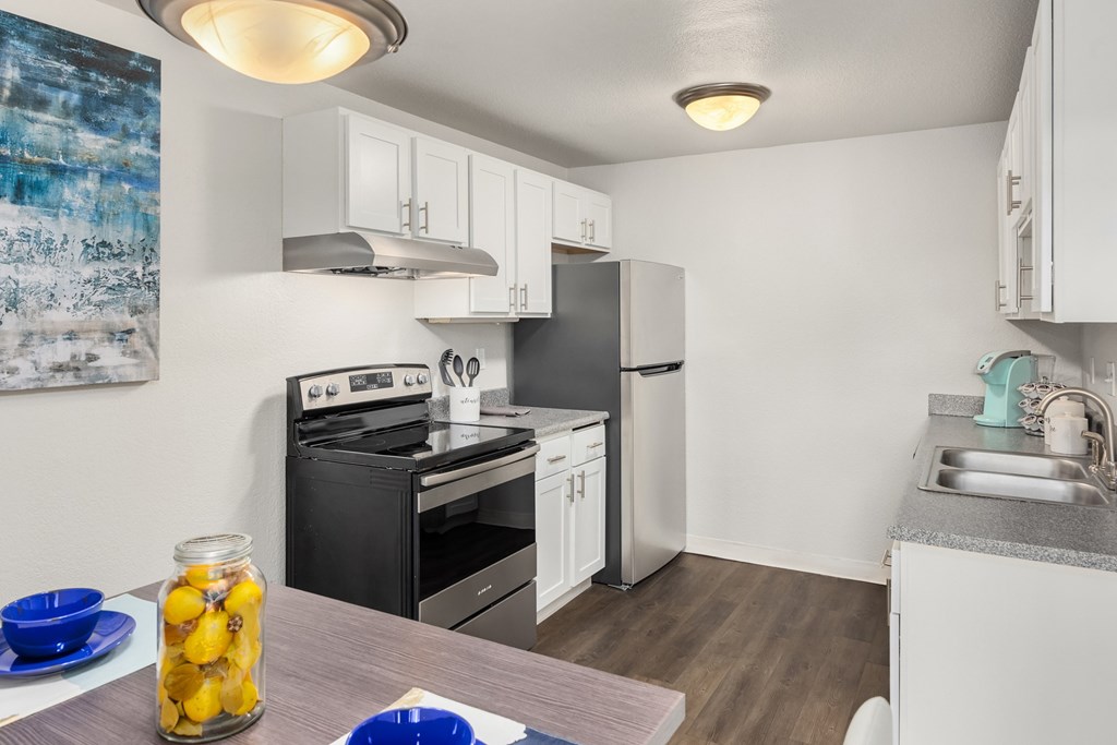 A kitchen with a black oven and white cabinets.