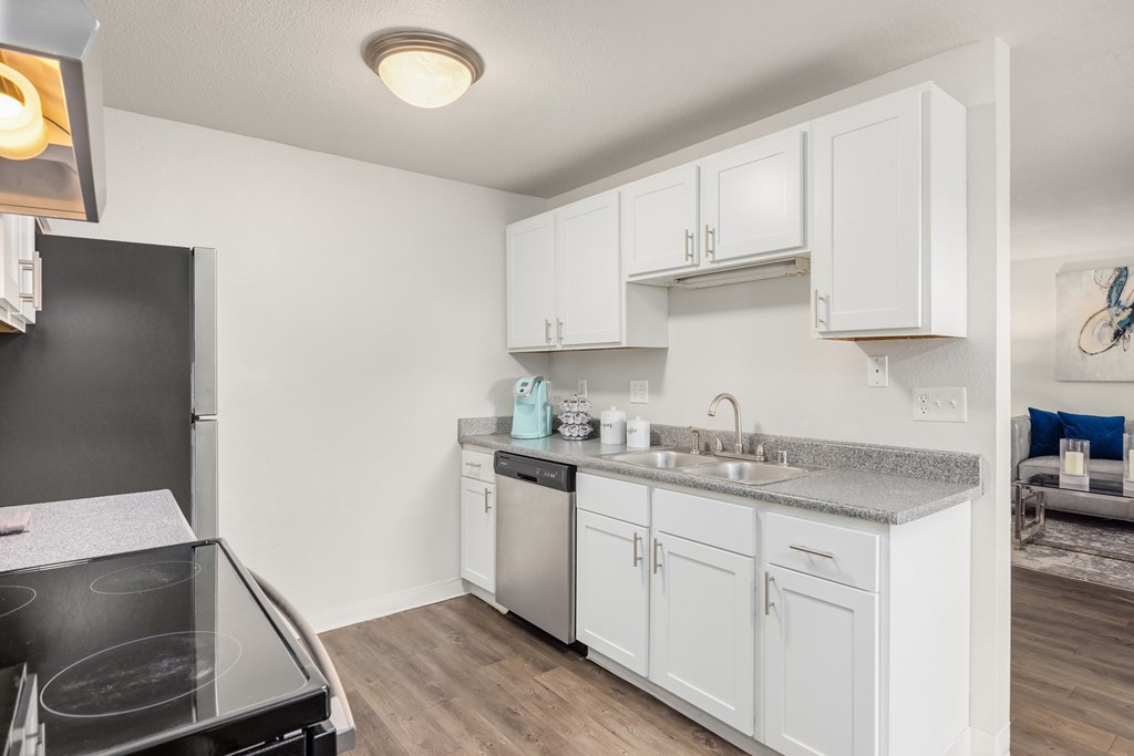 A kitchen with white cabinets and a black stove top.