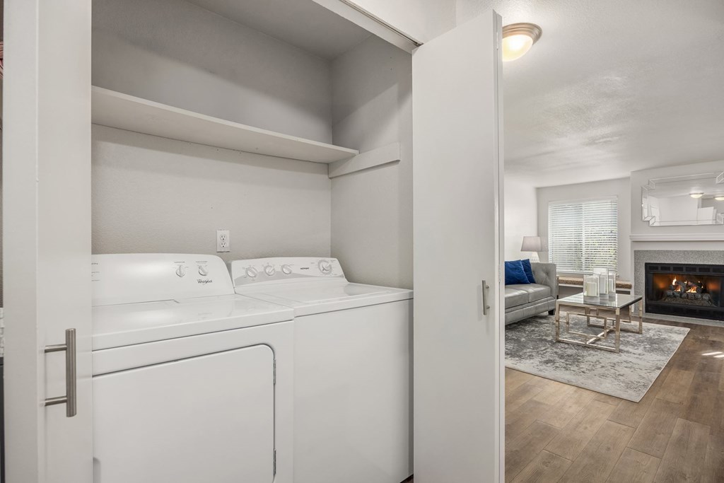 A white washing machine is in a small laundry room.