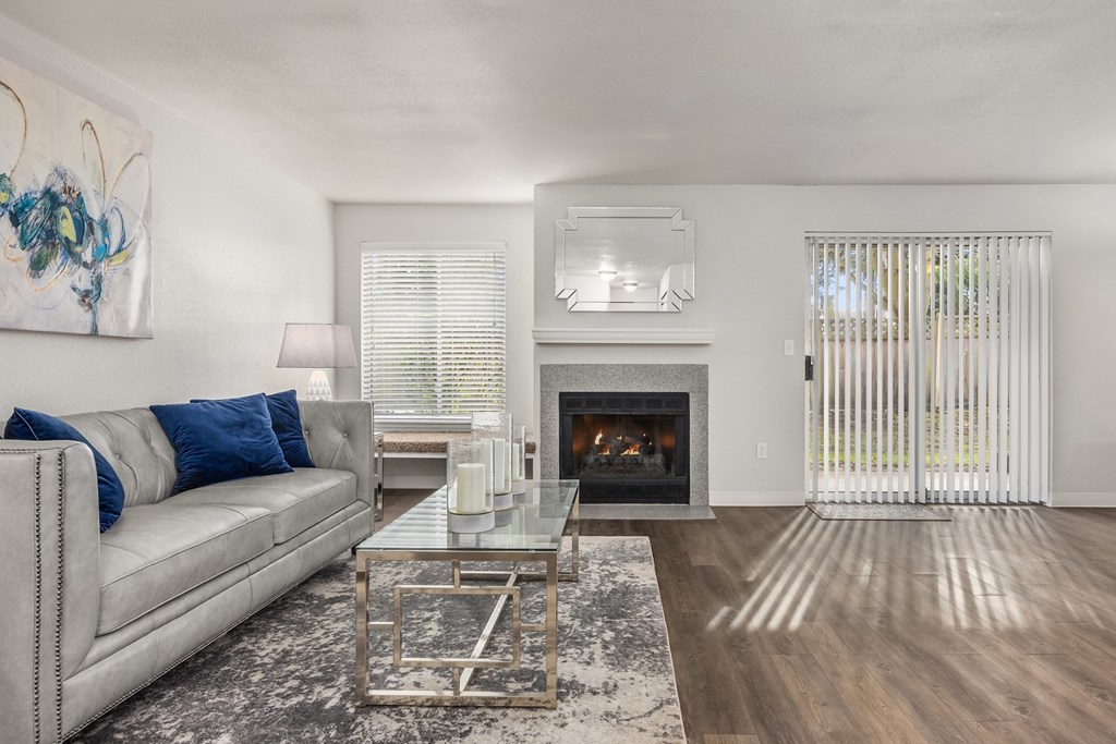 A modern living room with a grey couch and a fireplace.