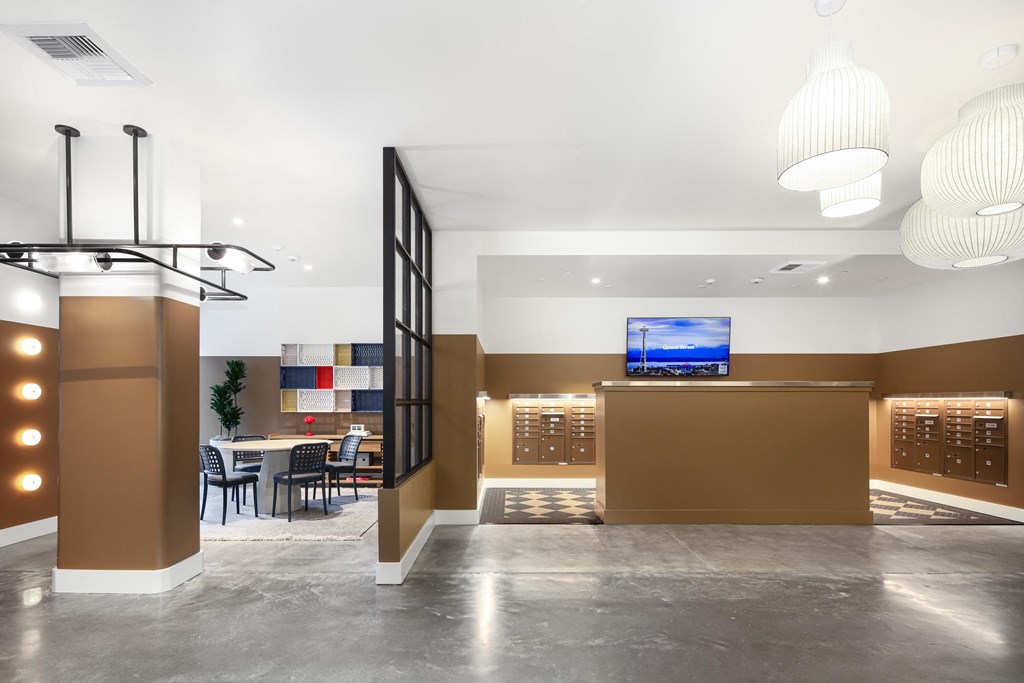 A modern office lobby with a reception desk and a television mounted on the wall.