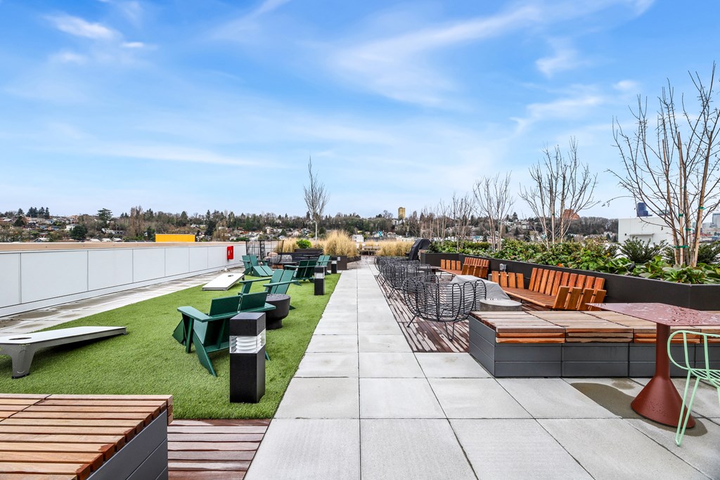 A rooftop patio with benches and tables.