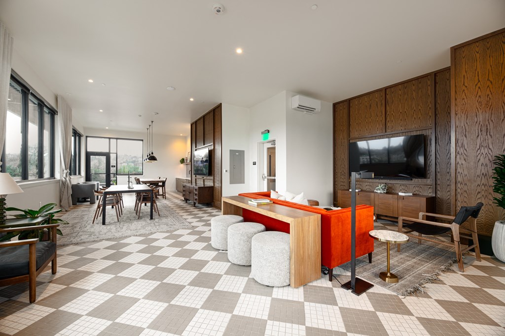 A modern living room with a checkered floor and a television.