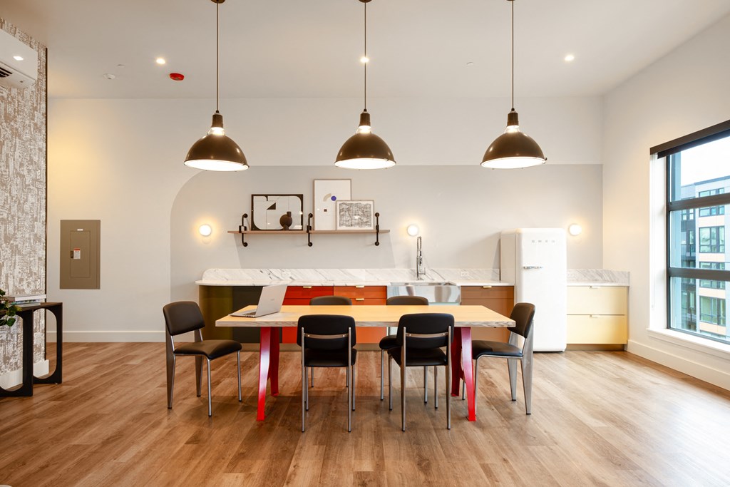 A modern dining room with a white table and black chairs.