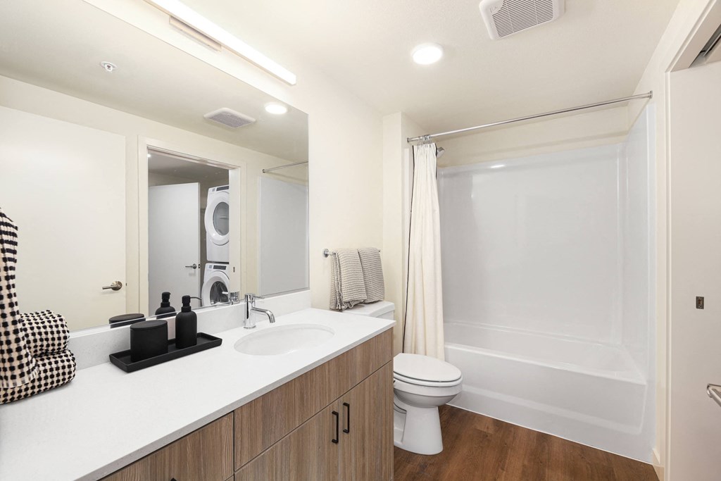A white bathroom with a toilet, sink, and mirror.