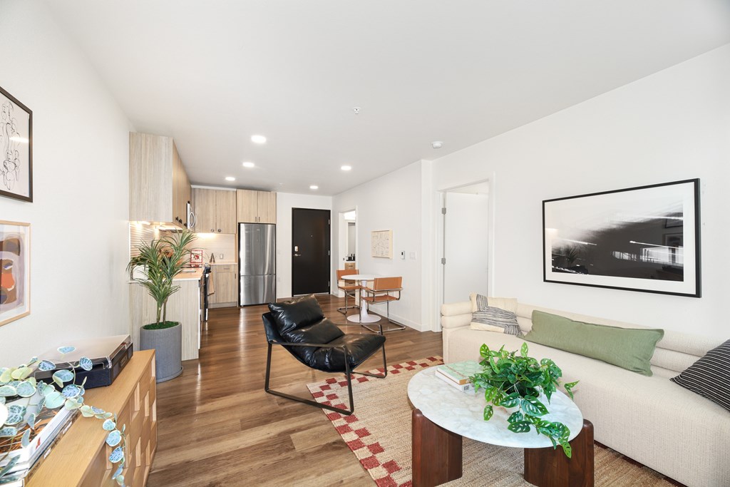 A living room with a black chair and a white couch.