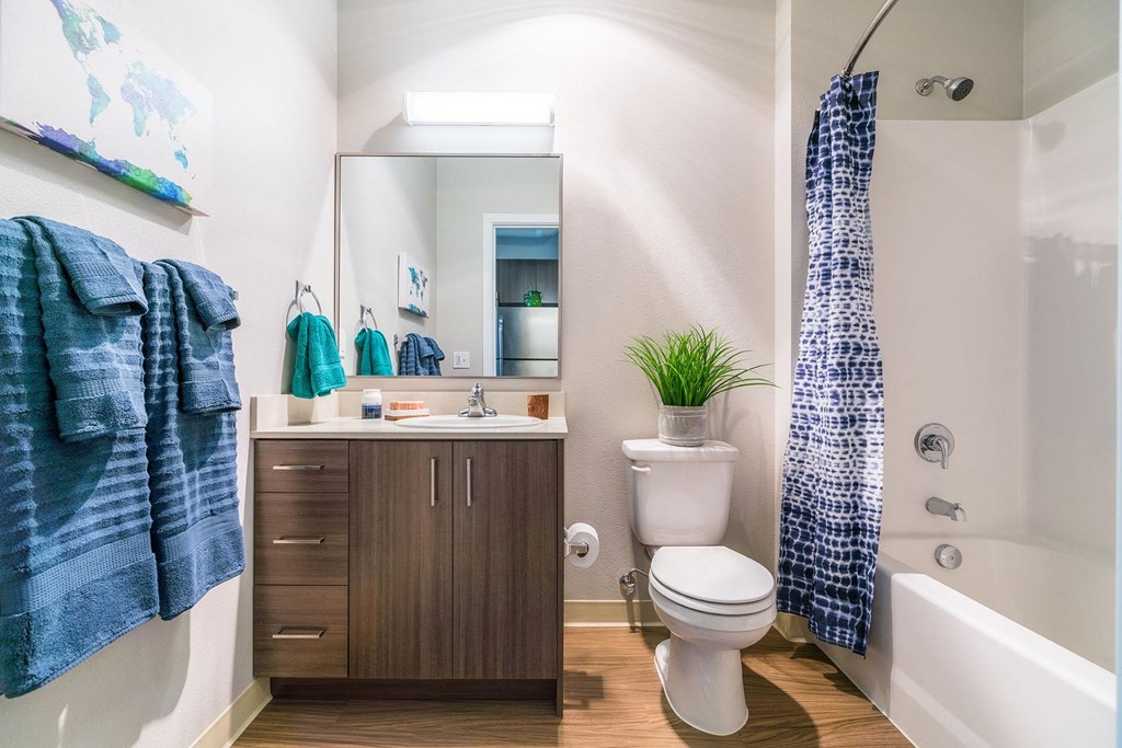 a bathroom with a toilet sink and shower and a mirror