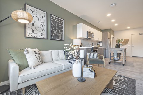 A modern living room with a white couch and a wooden coffee table.