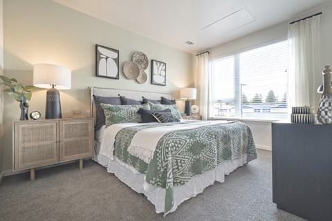 A bedroom with a large bed and a wooden cabinet.