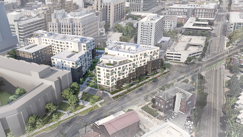A cityscape with buildings of various heights and a bridge in the background.