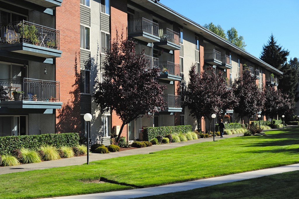 an exterior view of a building with green grass and trees