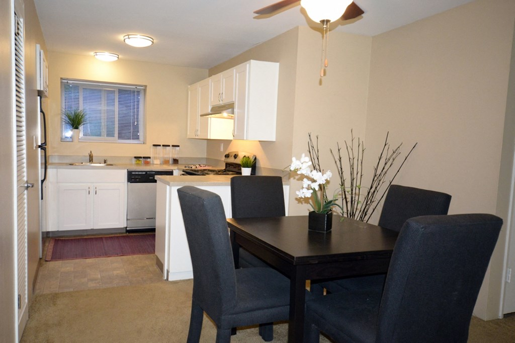 a dining room and kitchen with a table and chairs