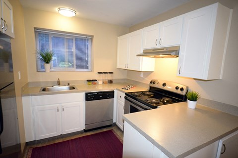 a kitchen with white cabinets and stainless steel appliances