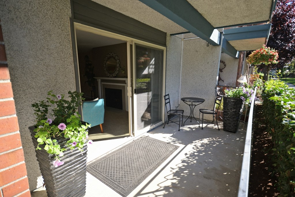 a patio with a table and chairs outside of a building