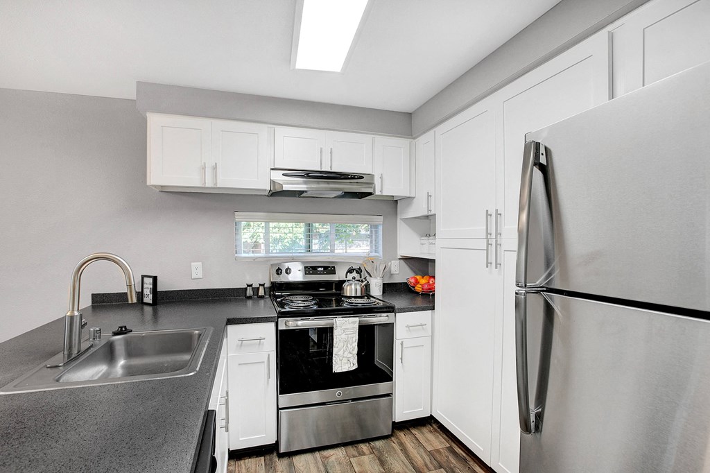a kitchen with white cabinets and stainless steel appliances