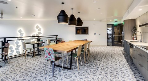 A dining area with a patterned floor and a wooden table with chairs.