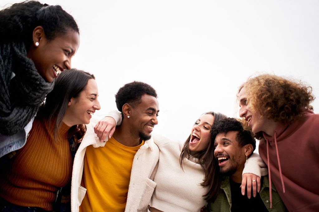 a group of people laughing and embracing each other