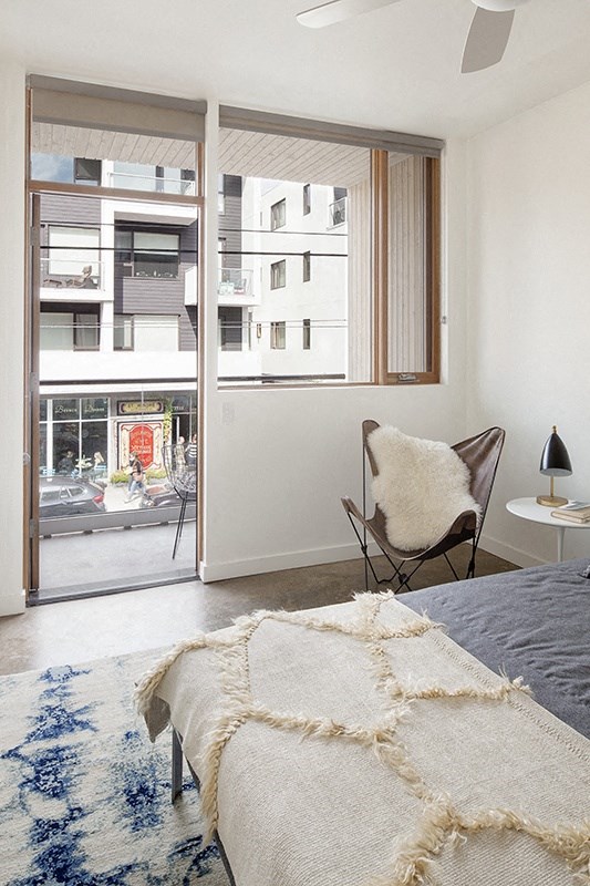 a bedroom with a bed and a chair and a window