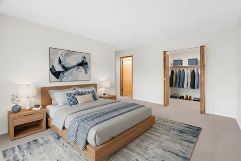 A bedroom with a large bed and a painting on the wall.