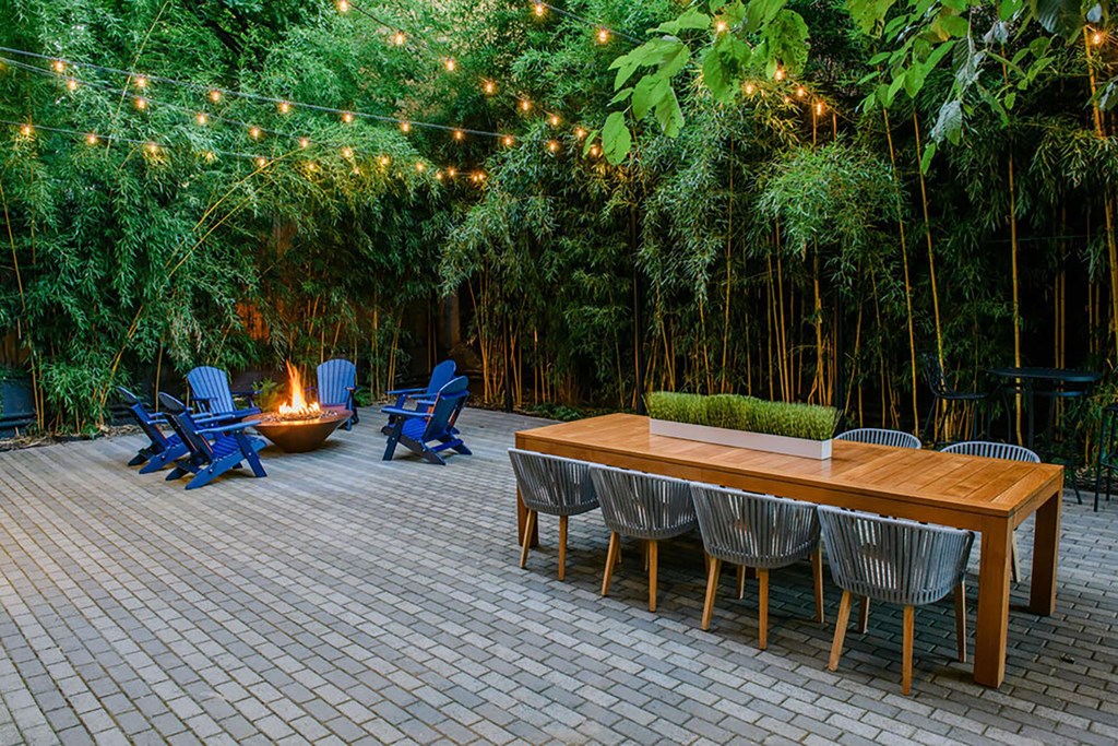 a patio with a table and chairs and a fire pit