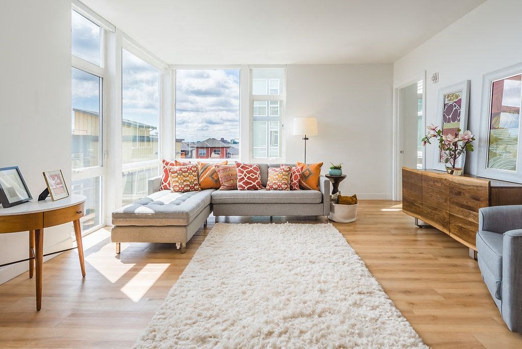 a living room with a gray couch and a white rug