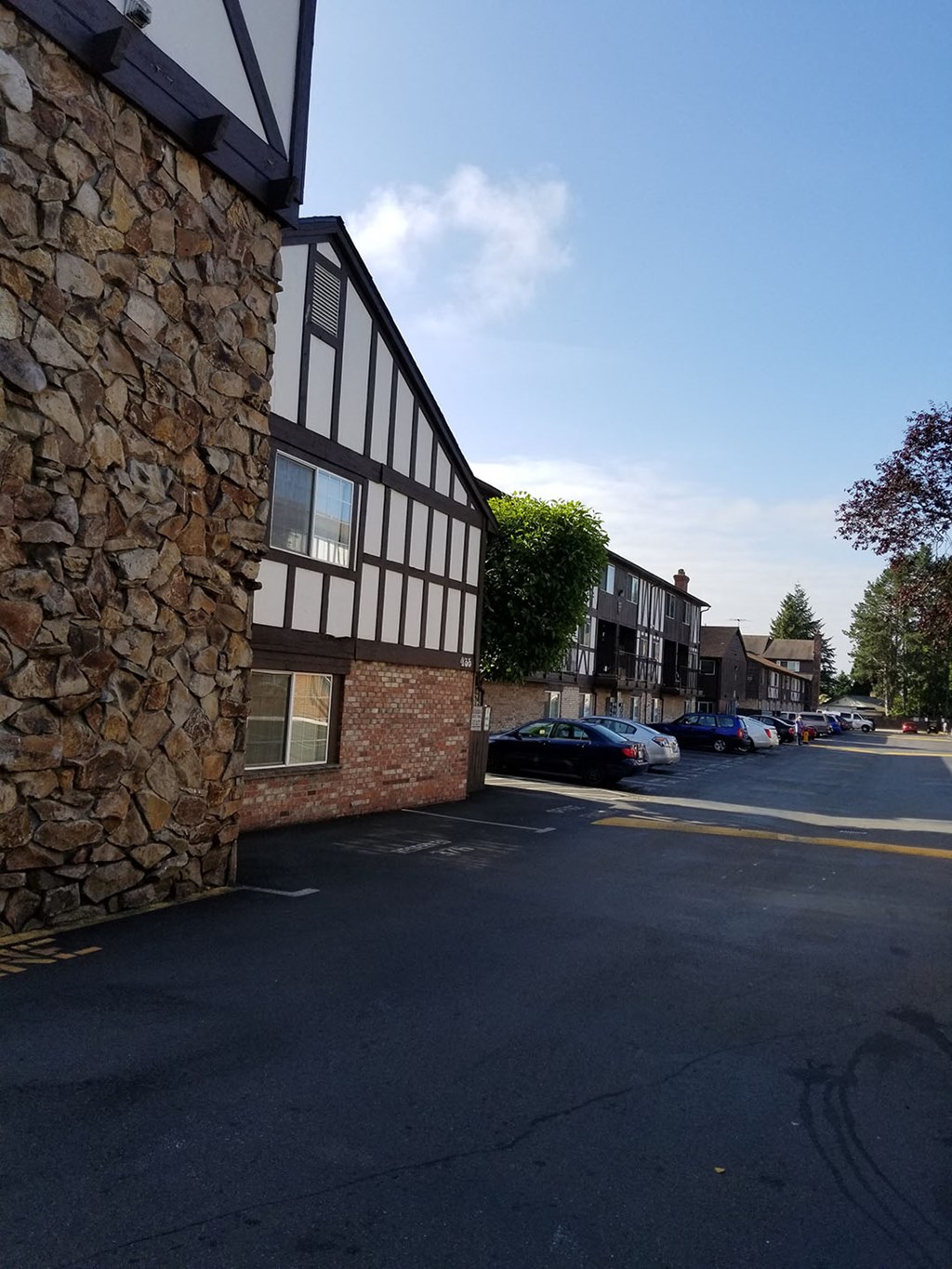 a street with a building and cars parked on the side of it