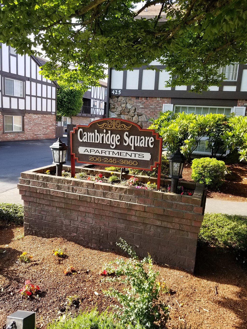 a sign for the cambridge square apartments in front of a brick wall