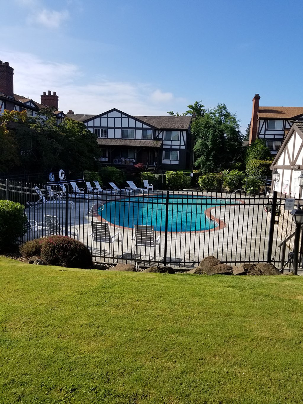 a swimming pool in a backyard behind a wrought iron fence