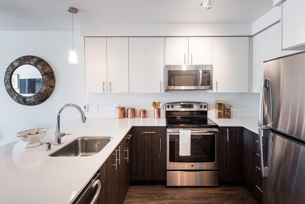 a kitchen with white countertops and dark wood cabinets