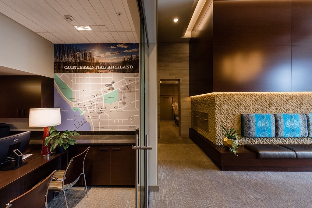 a lobby with a map of the city on the wall and a couch with blue pillows