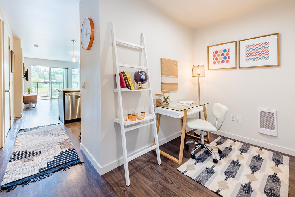 a white desk with a white chair and a white ladder shelf with books and a lamp