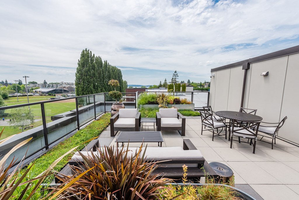 a roof terrace with a table and chairs and a firepit